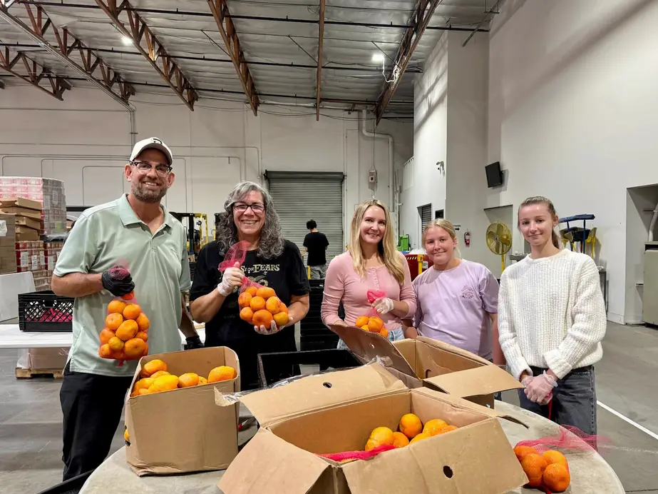 Five Bridge Church volunteers holding bags of oranges while serving neighbours