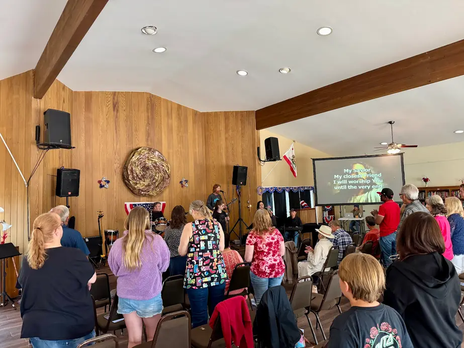 Sunday worship at The Bridge Church seen from the back of the clubhouse hall, the congregation facing the lyrics screen